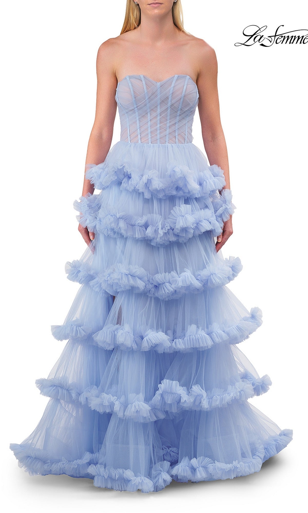 A woman wears the Strapless Tiered Prom Ball Gown: La Femme 33717 in light blue, showcasing a sweetheart neckline and a flowing ball gown silhouette with elegant tiered tulle ruffles. The structured upper bodice features sheer paneling, perfectly enhancing the romantic design. The brand name “La Femme 33717” is displayed in the top right corner.